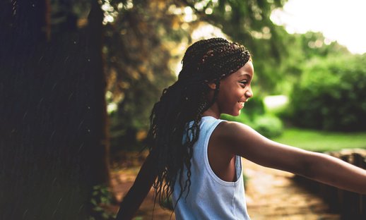 Child girl outside happy nature community - National Literacy Trust