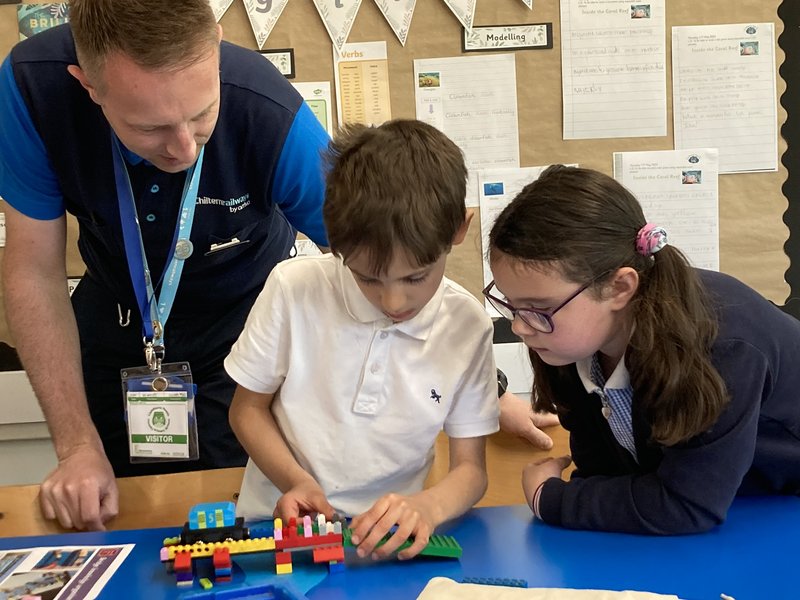 A volunteer from Chiltern Railways helps children in our Dream Big classroom workshop