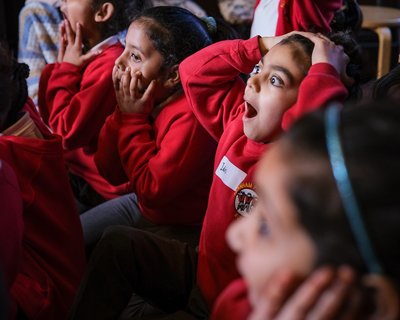 Primary students holding heads in amazement during story time