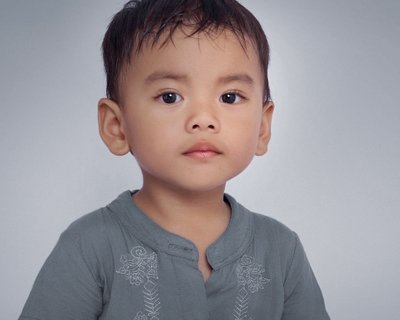 Toddler boy looks directly at camera Cost of Literacy Crisis Campaign