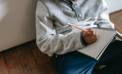 Writing in notebook on lap