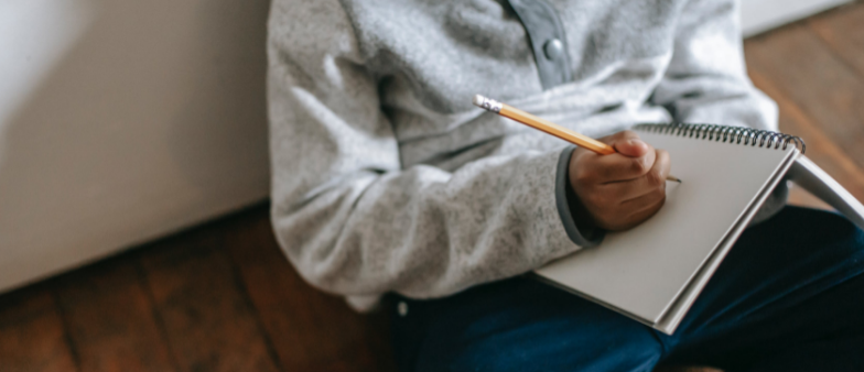 Writing in notebook on lap