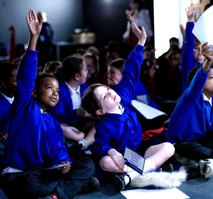 Primary pupils with hands up