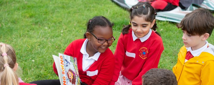 Primary children reading outdoors