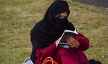 Adult literacy - woman reads a book in the park
