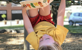 Child reading a book outside
