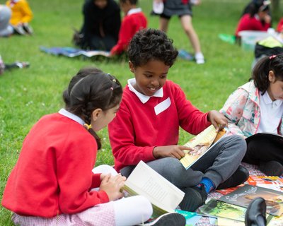 Children outside chatting about a book