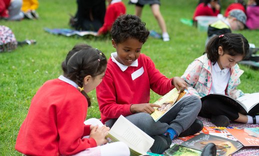Children outside chatting about a book
