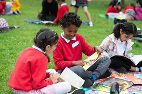 Children outside chatting about a book