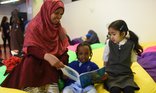 Woman and 2 girls reading