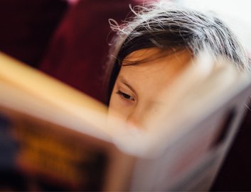 Close up of a young child reading a book