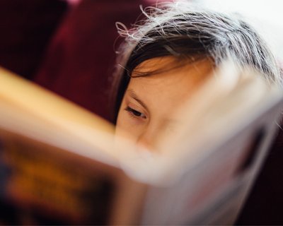 Close up of a young child reading a book