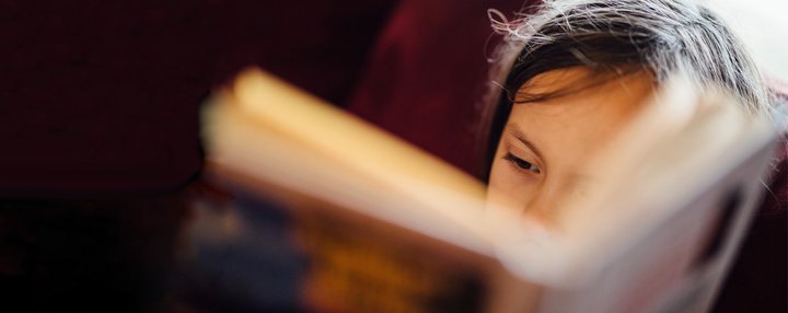 Close up of a young child reading a book