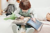 A toddler looks at a picture book