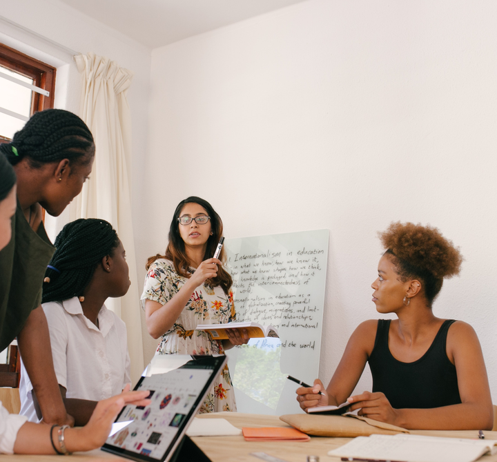 A woman presenting to colleagues in a meeting setting